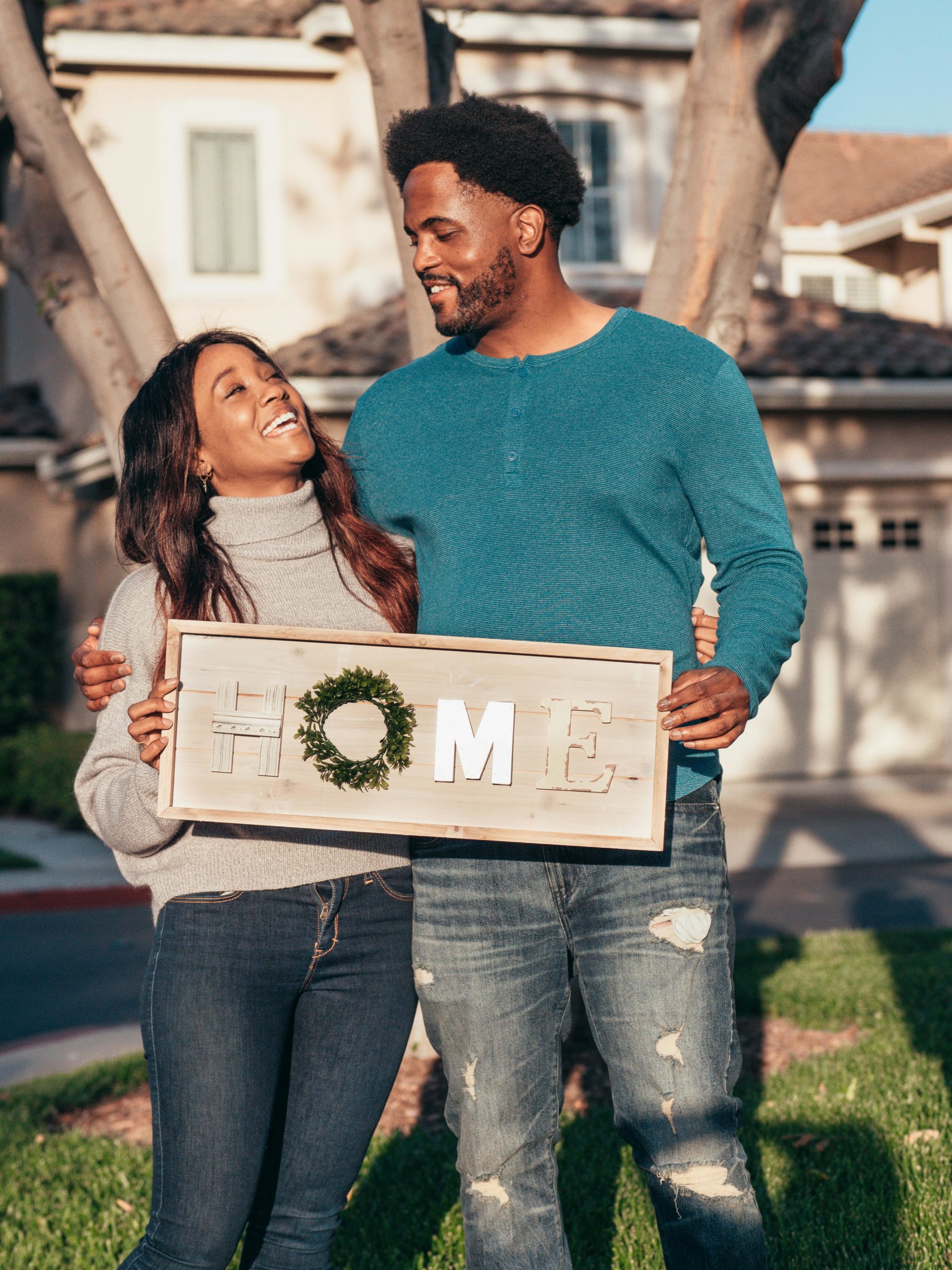 Couple out front of their new home taking first picture